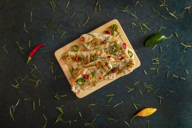 Grilled chicken breast cooked with three different colors chili peppers and aromatic herbs.