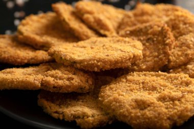 Macro close-up of homemade zucchini chips cooked with gluten free bread crumb, rice flour, extra virgin olive oil and salt. 