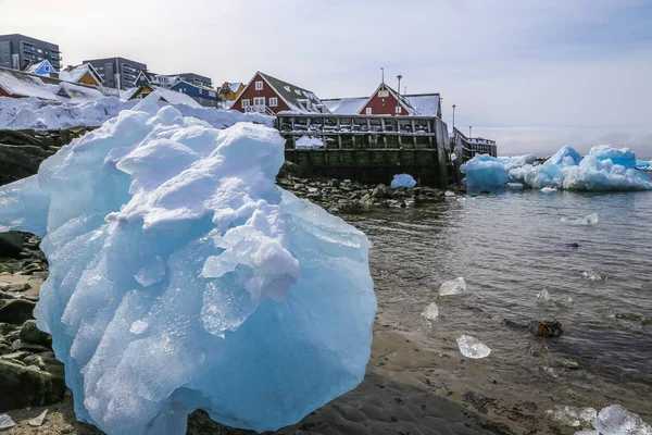 Duży Kawałek Niebieski Lód Wśród Kamieni Brzegu Inuitów Nowoczesnego Budynku — Zdjęcie stockowe
