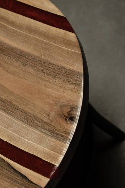 Pahalı eski mobilyalar. Masa epoksi reçineyle kaplanmış ve verniklenmiş. Lüks kaliteli ahşap işleme. Beton zeminde tahta bir masa. Yuvarlak bir ağaç tabakasında kırmızı bir epoksi nehri.