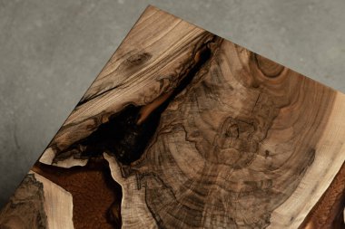 Pahalı eski mobilyalar. Masa epoksi reçineyle kaplanmış ve verniklenmiş. Lüks kaliteli ahşap işleme. Koyu arkaplanda tahta bir masa. Dikdörtgen bir ağaç tablasında altın bir epoksi nehri..