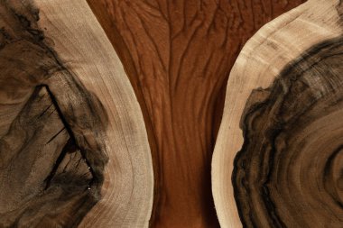 Pahalı eski mobilyalar. Masa epoksi reçineyle kaplanmış ve verniklenmiş. Lüks kaliteli ahşap işleme. Koyu arkaplanda tahta bir masa. Dikdörtgen bir ağaç tablasında altın bir epoksi nehri..