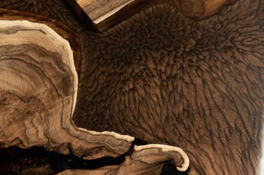 Pahalı eski mobilyalar. Masa epoksi reçineyle kaplanmış ve verniklenmiş. Lüks kaliteli ahşap işleme. Koyu arkaplanda tahta bir masa. Dikdörtgen bir ağaç tablasında altın bir epoksi nehri..