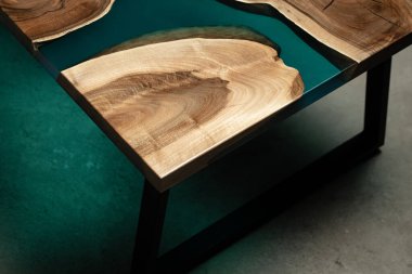 Pahalı eski mobilyalar. Masa epoksi reçineyle kaplanmış ve verniklenmiş. Lüks kaliteli ahşap işleme. Beton zeminde tahta bir masa. Dikdörtgen bir levhada bir deniz tutkalı nehri..