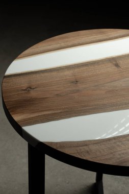 Pahalı eski mobilyalar. Masa epoksi reçineyle kaplanmış ve verniklenmiş. Lüks kaliteli ahşap işleme. Koyu arkaplanda tahta bir masa. İş teklifi kavramı.