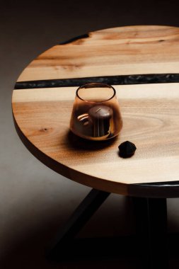 Klasik doğal ahşap masada cam içinde zarif bir mum.