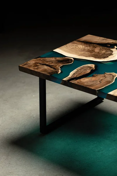 Pahalı eski mobilyalar. Masa epoksi reçineyle kaplanmış ve verniklenmiş. Lüks kaliteli ahşap işleme. Beton zeminde tahta bir masa. Dikdörtgen bir levhada bir deniz tutkalı nehri..