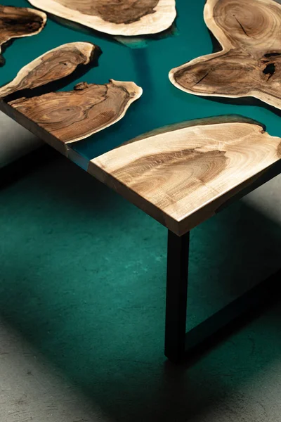 Pahalı eski mobilyalar. Masa epoksi reçineyle kaplanmış ve verniklenmiş. Lüks kaliteli ahşap işleme. Beton zeminde tahta bir masa. Dikdörtgen bir levhada bir deniz tutkalı nehri..