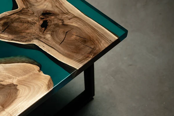 Pahalı eski mobilyalar. Masa epoksi reçineyle kaplanmış ve verniklenmiş. Lüks kaliteli ahşap işleme. Beton zeminde tahta bir masa. Dikdörtgen bir levhada bir deniz tutkalı nehri..