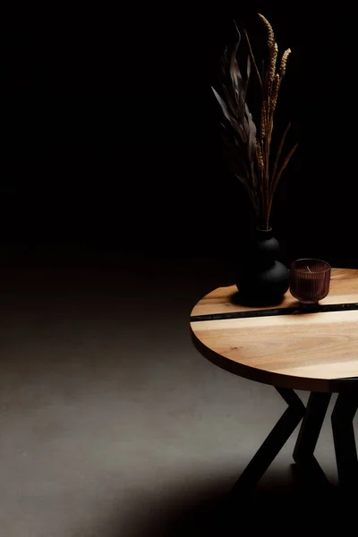 Pahalı eski mobilyalar. Masa epoksi reçineyle kaplanmış ve verniklenmiş. Lüks kaliteli ahşap işleme. Dekordaki kristal kristaller. Minimalist siyah bir vazoda bir buket kurumuş çiçek..