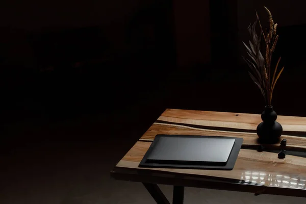 Pahalı eski mobilyalar. Masa epoksi reçineyle kaplanmış ve verniklenmiş. Lüks kaliteli ahşap işleme. Bir iş yerinde sahte bir standın üstündeki dizüstü bilgisayar..