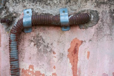 Duvardaki paslı metal boru.