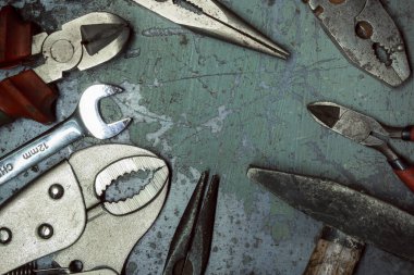 Ahşap arka planda eski paslı İngiliz anahtarı ve çekiç