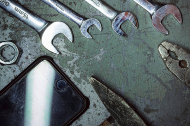 old rusty wrench and hammer on a wooden background.