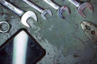 old rusty wrench and hammer on a dark background.