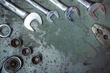 old rusty metal wrench and bolts on a dark background.