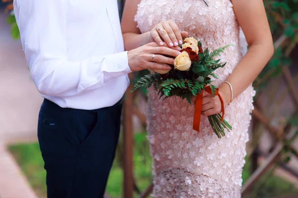 Wedding bouquet in the hands of the bride at the ceremony.