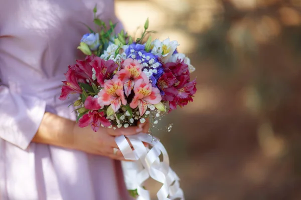 Wedding bouquet in the hands of the bride at the ceremony.