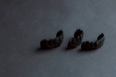 Diş protezi laboratuarı konsepti. 3 boyutlu modelleme için insan dişleri. Çene köprüsü 3D siyah arkaplan üzerindeki bir fotopolimer materyalden yazdırıldı.