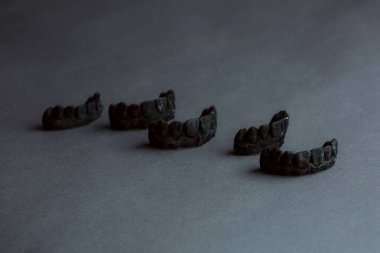 Diş protezi laboratuarı konsepti. 3 boyutlu modelleme için insan dişleri. Çene köprüsü 3D siyah arkaplan üzerindeki bir fotopolimer materyalden yazdırıldı.