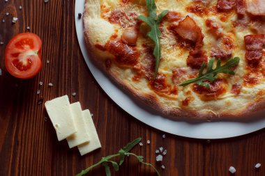 Tahta bir masada etli ve sebzeli pizza. 