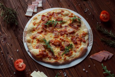 Tahta bir masada etli ve sebzeli pizza. 