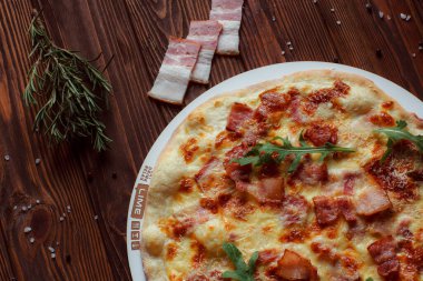 Tahta bir masada etli ve sebzeli pizza. 