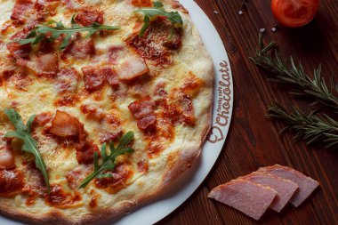 Tahta bir masada etli ve sebzeli pizza. 