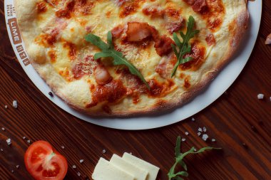 Tahta bir masada etli ve sebzeli pizza. 