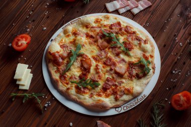 Tahta bir masada etli ve sebzeli pizza. 