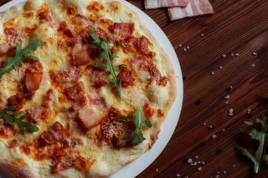 Tahta bir masada etli ve sebzeli pizza. 