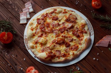 Tahta bir masada etli ve sebzeli pizza. 