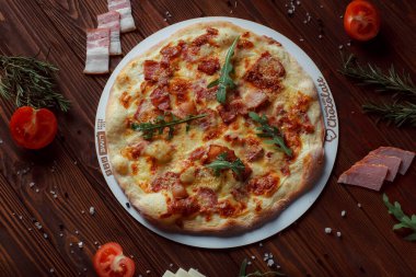 Tahta bir masada etli ve sebzeli pizza. 