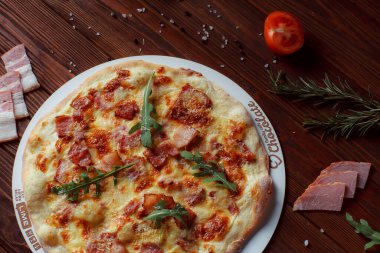 Tahta bir masada etli ve sebzeli pizza. 