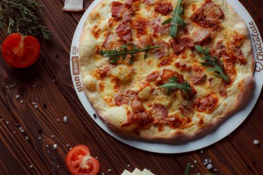 Tahta bir masada etli ve sebzeli pizza. 