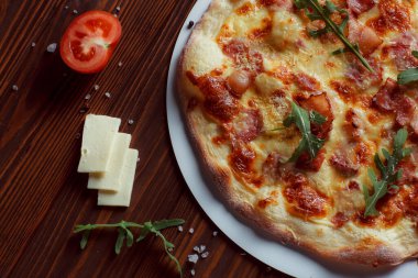 Tahta bir masada etli ve sebzeli pizza. 