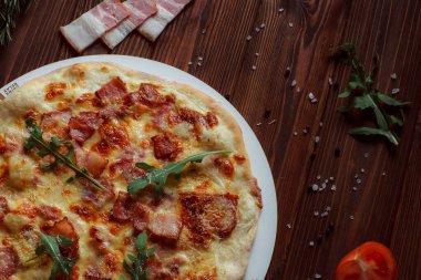 Tahta bir masada etli ve sebzeli pizza. 