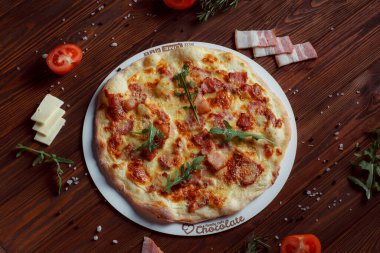 Tahta bir masada etli ve sebzeli pizza. 