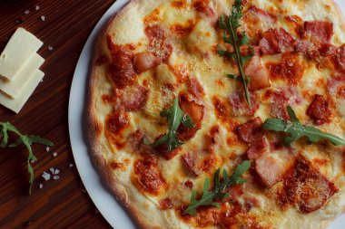 Tahta bir masada etli ve sebzeli pizza. 