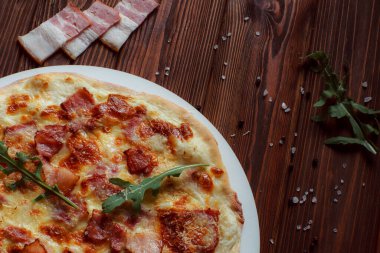 Tahta bir masada etli ve sebzeli pizza. 