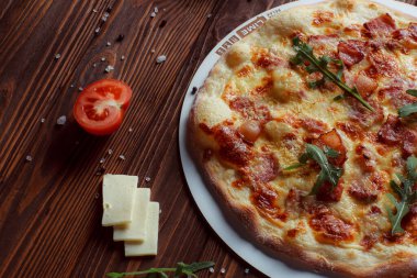 Tahta bir masada etli ve sebzeli pizza. 