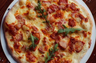 Tahta bir masada etli ve sebzeli pizza. 