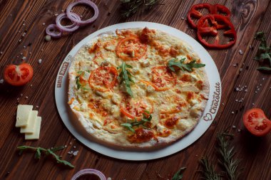 Tahta bir masada etli ve sebzeli pizza. 