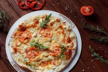 Tahta bir masada etli ve sebzeli pizza. 