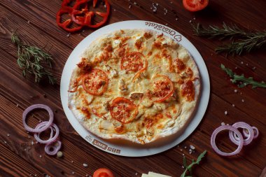 Tahta bir masada etli ve sebzeli pizza. 