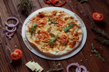 Tahta bir masada etli ve sebzeli pizza. 