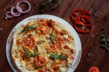 Tahta bir masada etli ve sebzeli pizza. 