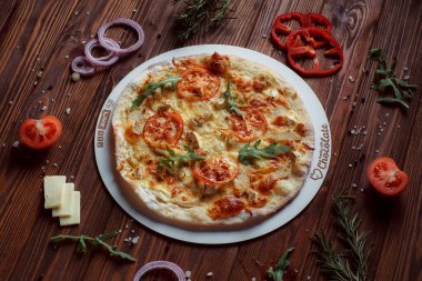 Tahta bir masada etli ve sebzeli pizza. 