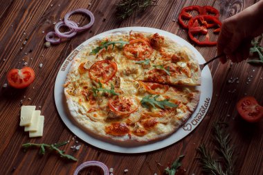 Tahta bir masada etli ve sebzeli pizza. 