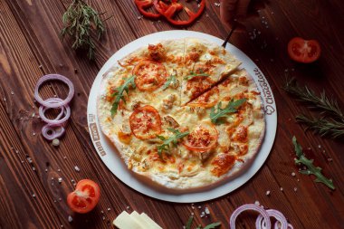 Tahta bir masada etli ve sebzeli pizza. 